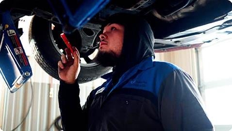 image of a mechanic looking under a car