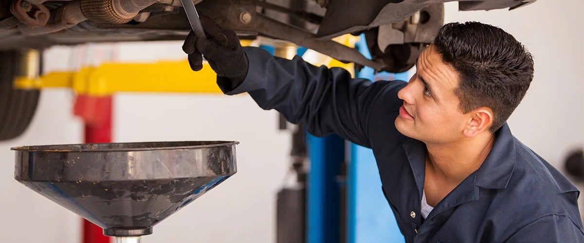 image of a mechanic looking under a car
