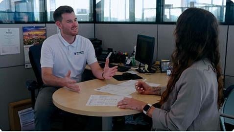image of a man speaking to a woman at a desk